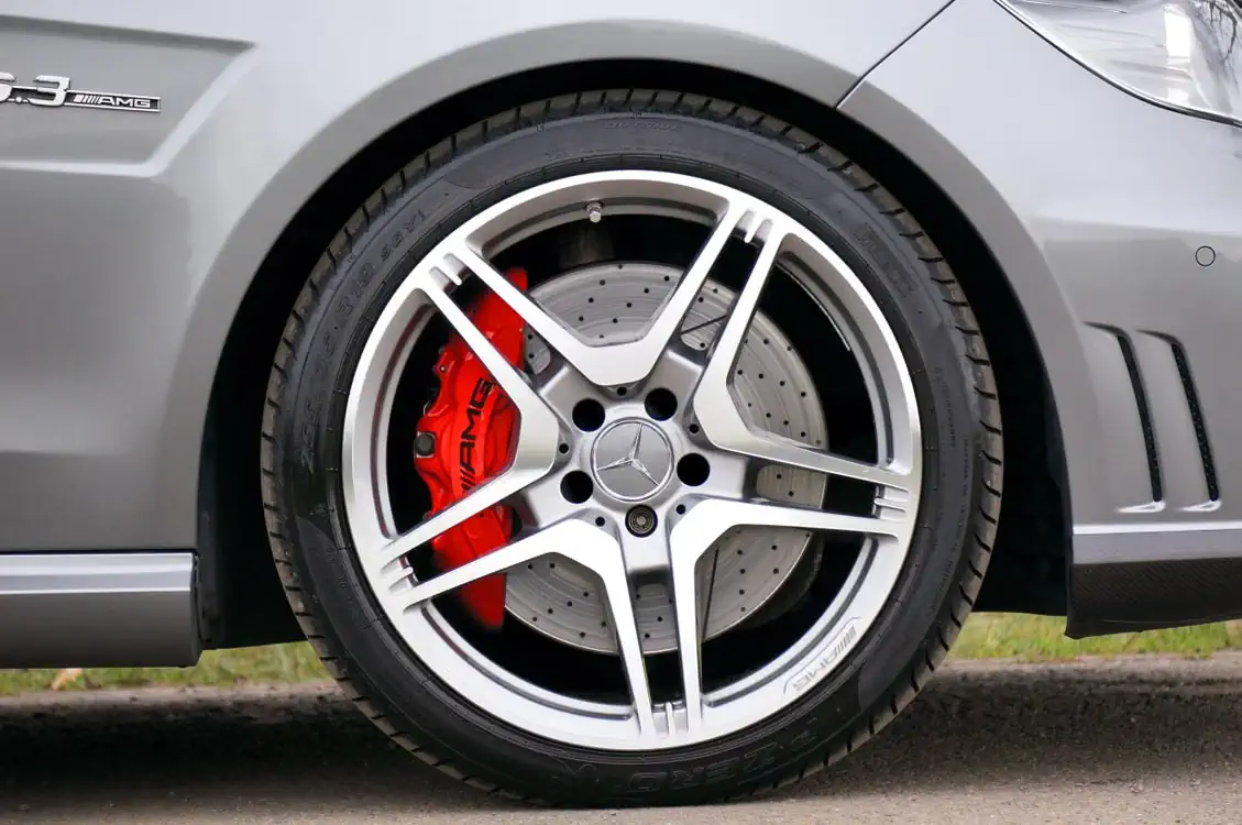 Silver alloy wheel with a red brake caliper on a car