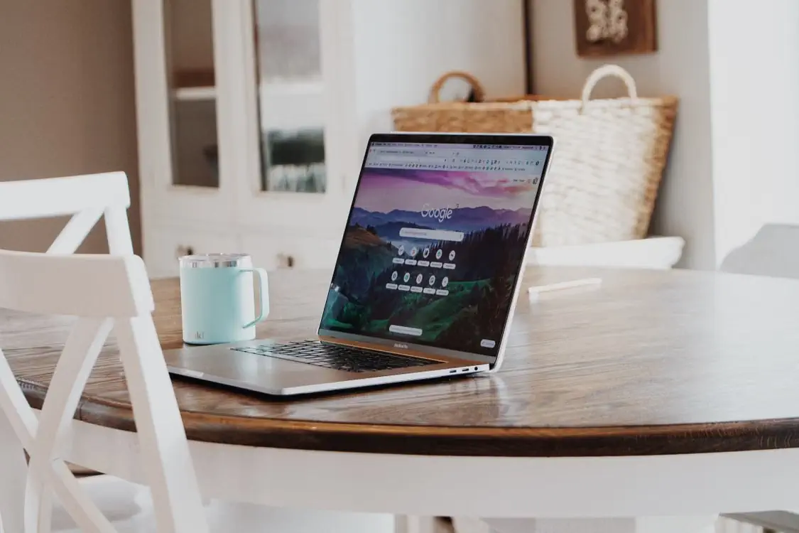 Open laptop on a wooden table in a bright home, ready for an online property search in the Baltics